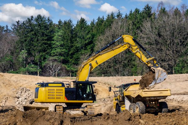 Yellow earth mover filling a lorry at a construction site